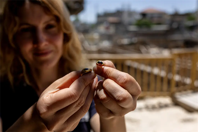Marion Zindel, from the Israel Antiquities Authority holds the 2,300-year-old gold rings after being unearthed at the archaeological site in Jerusalem.