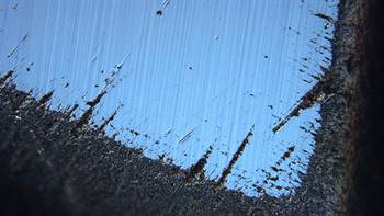 Differential interference contrast image near an apex of the stone showing the roughening of junctions between the faces and evidence of polishing after the roughening occurred. Image by David Fisher; field of view 0.48 mm.